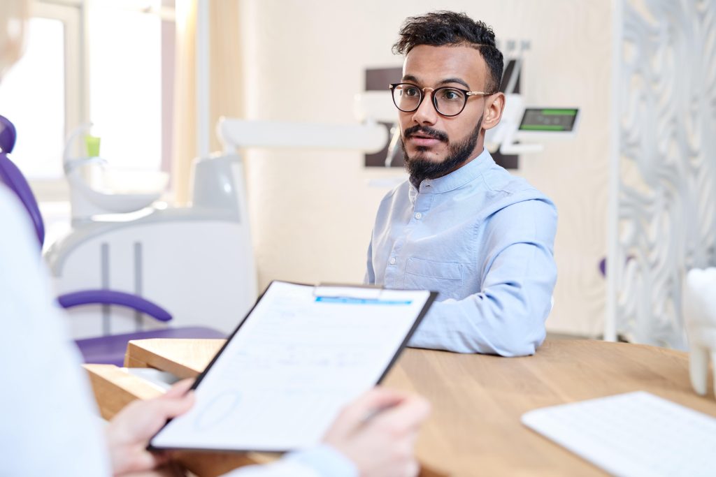 man speaking to a dentist at an orthodontic consultation